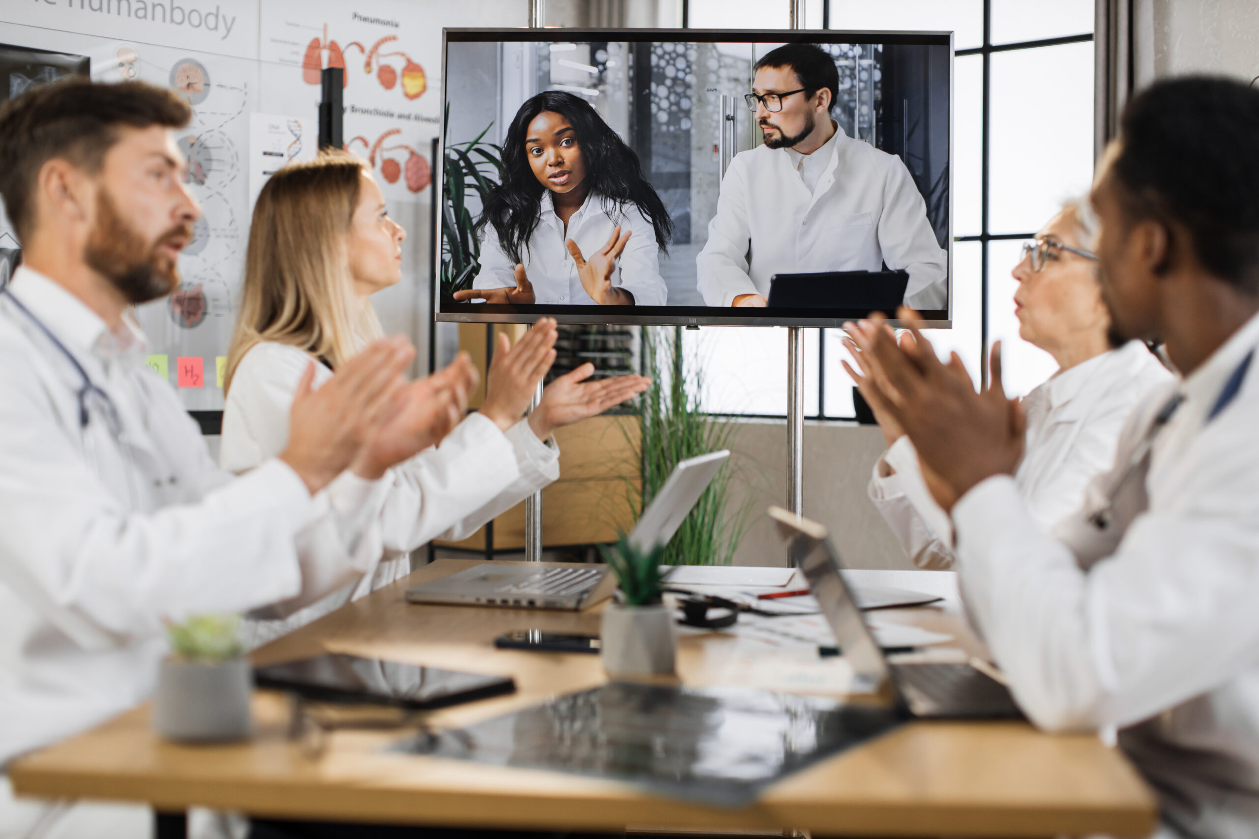 Multicultural doctors clapping during online presentation